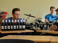 Zwei Jungs machen Musik auf Bierflaschen.  